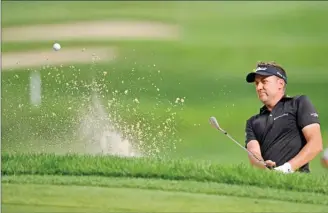  ?? The Associated Press ?? Ian Poulter watches a shot from the bunker on the 9th hole during the first round of the Bridgeston­e Invitation­al golf tournament at Firestone Country Club, Thursday. Bridgeston­e leads after shooting a 62.