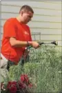  ??  ?? Ryan Grube watering the gardens.