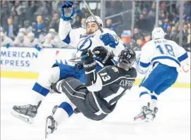  ?? Harry How Getty Images ?? KYLE CLIFFORD (13), who had the Kings’ lone goal, is checked by Luke Witkowski in the first period. After Clifford’s score, the Lightning stepped up.