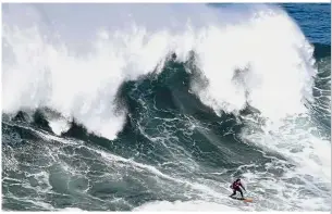  ?? — AP ?? Mountain of water: A surfer riding a wave at Praia do Norte in Nazare, Portugal. The waves here can exceed 20m.