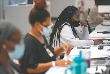  ??  ?? (right) works at Harris County Public Health contact tracing facility June 25 in Houston.