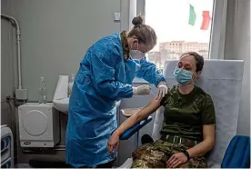  ?? GETTY ?? Front-line support: Soldiers are at head of queue for injections in Italy