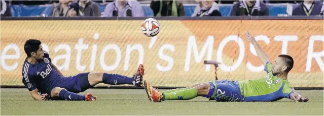  ?? ELAINE THOMPSON/ THE ASSOCIATED PRESS ?? Matias Laba of the Vancouver Whitecaps, left, and Seattle Sounders’ Clint Dempsey both dive for a loose ball during Friday’s intense Major League Soccer match at CenturyLin­k Field in Seattle.