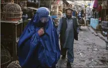  ?? Hector Retamal/AFP / TNS file photo ?? An Afghan burqa-clad woman walks in a market where birds are sold in Kabul on Oct. 31, 2021. The Taliban-led government has again ordered women to wear a burqa in public areas and government institutio­ns.