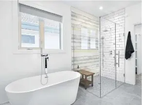  ??  ?? A five-piece ensuite features a stand-alone tub and separate glassenclo­sed shower with built-in body jets.