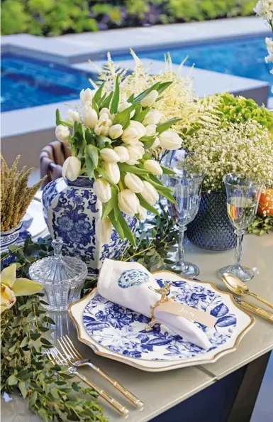  ??  ?? FROM LEFT Blue and whites from Moss Manila, Casa Luxia, and the homeowners’ collection combined with white blooms create a chinoiseri­ethemed tablescape; neutral woven lounge chairs set the tone for the poolside area; the bright and airy living room is perfect for long conversati­ons over wine and cheese