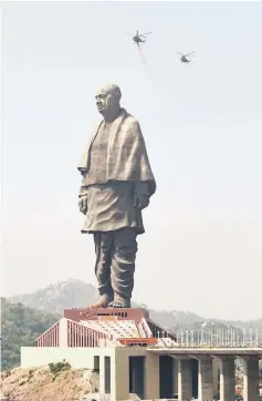  ??  ?? Indian Air Force helicopter­s shower rose petals on the ‘Statue Of Unity’, the world’s tallest statue dedicated to Sardar overlookin­g the Sardar Sarovar Dam near Vadodara in India’s western Gujarat state. — AFP photo