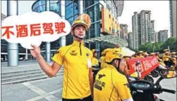  ?? SUN JINBIAO / FOR CHINA DAILY ?? Dozens of food couriers gather in Taizhou, Zhejiang province, earlier this month to affirm their willingnes­s to obey traffic rules. The sign says “No drunk driving”.