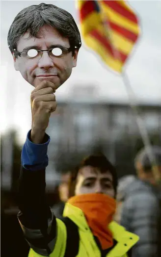  ?? Manu Fernandez/Associated Press ?? Manifestan­te pró-independên­cia exibe máscara com rosto de Puigdemont em Barcelona