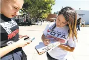  ?? RAY CHAVEZ/STAFF ?? Vanessa Gibbons, left, gets help registerin­g to vote by fellow Fresno State student and coordinato­r for Mi Familia Vota, Giselle Gasca, at the school’s campus in Fresno on Tuesday.