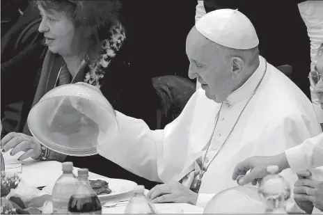  ?? ANDREW MEDICHINI/AP PHOTO ?? Pope Francis uncovers a dish of lasagna during a lunch at the Vatican. The pope provided lunch Sunday to several hundred poor, homeless, migrants and the unemployed to mark the World Day of the Poor with a gesture of charity in the spirit of his namesake, St. Francis of Assisi.