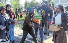  ?? Picture: ABONGILE SOLUNDWANA ?? REACHING OUT: Sisters Lindiwe Gatyeni, Yoliswa Majola and Thandi Booi hand out fruit to hungry unemployed men at Komani and Griffith streets.