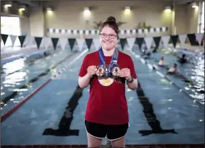  ?? Arkansas Democrat-Gazette/MITCHELL PE MASILUN ?? Becky Carter poses for a portrait with her two medals at the Jim Dailey Fitness &amp; Aquatic Center in Little Rock on Wednesday.