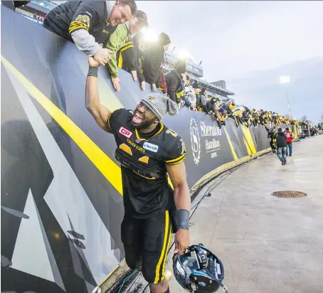  ?? ERNEST DOROSZUK ?? Hamilton Tiger-Cats defensive stalwart Simoni Lawrence exchanges high-fives with the fans at Tim Hortons Field, who have fully embraced this year’s exciting, competitiv­e team. The Ticats take a three-game winning streak into their showdown against the Stampeders on Saturday.