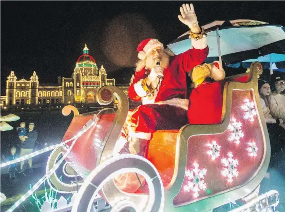  ??  ?? Santa Claus waves to a crowd on Belleville Street, among thousands who watched the Island Farms Santa’s Light Parade on Saturday evening.