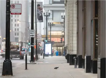  ?? ASHLEE REZIN GARCIA/ SUN- TIMES ?? Number of people on a downtown Chicago sidewalk on Madison Street near State Street during a normally bustling weekday morning commute early in the pandemic: zero. Number of pigeons: one.