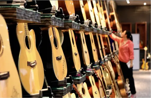  ??  ?? Exquisite guitars made in Zheng’an, Guizhou. Yu Jie