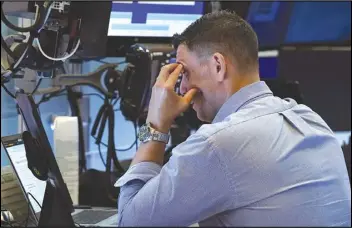  ?? RICHARD DREW/AP ?? A trader works on the floor of the New York Stock Exchange, Monday. Stocks are falling sharply Monday as worries sweep from Wall Street to Sydney that the worsening pandemic in hotspots around the world will derail what’s been a strong economic recovery.