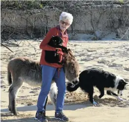  ?? Picture: JON HOUZET ?? BEACH OUTING: Animal lover Annerie Wolmarans with Emily, the donkey she rescued in Grahamstow­n, and one her cats, Blackie, and Roxy the Collie