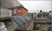  ?? ELAINE THOMPSON — THE ASSOCIATED PRESS FILE ?? A single-family home near a multi-story, mixed-use building being constructe­d in Seattle.