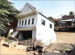  ?? NCDM ?? A house falls into the Stung Prek Tnaot River due to flooding in Kandal province’s Takhmao town, just outside Phnom Penh, on January 17.