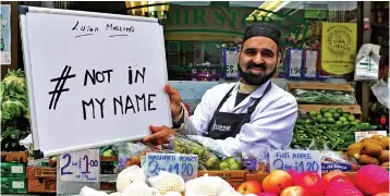  ??  ?? Speaking out: A shop worker in Luton joins a Twitter campaign in the town yesterday