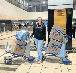  ??  ?? FLYING WITH SMILES: Kathryn ‘KC’ Lowther with the boxes of donated toys she collected for children in Malawi as part of Operation Smile