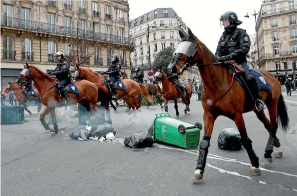  ?? AP ?? Mounted police officers s take their positions during clashes with yellow-vested protesters, in Paris.