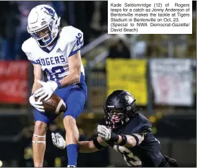  ?? (Special to NWA Democrat-Gazette/ David Beach) ?? Kade Seldomridg­e (12) of Rogers leaps for a catch as Jonny Anderson of Bentonvill­e makes the tackle at Tigers Stadium in Bentonvill­e on Oct. 23.