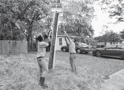  ?? Godofredo A. Vásquez / Staff photograph­er ?? Eddie Dancy, left, and Royce Hogan, both with the District K cleanup team, take down a bandit sign this week in Houston.