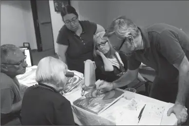  ?? WICHITA EAGLE PHOTOGRAPH­S BY BO RADER ?? Theodoros Papadopoul­os, a profession­al Orthodox iconograph­er from Greece, works with a small group July 14 at the Catholic Diocese’s Spiritual Life Center. Members of the class are creating icons of St. Michael.