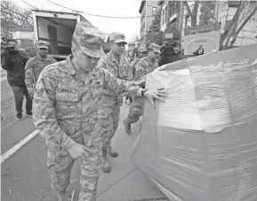  ?? MARK VERGARI/USA TODAY NETWORK ?? Members of the New York Air and Army National Guard move a pallet of bananas in New Rochelle, N.Y., on March 12. The Army is altering bases that prepare troops for combat to accommodat­e National Guard units.