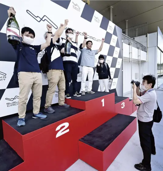  ?? ?? Participan­ts on a tour stand on the podium at Suzuka Circuit.