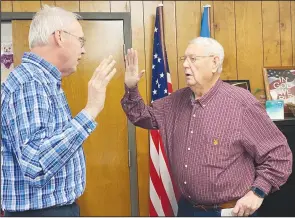  ?? PDN photo by David Seeley ?? Poteau Public Schools Board of Education Clerk Earl Jobe, right, swears in new board member Troy George at the start of Monday night’s meeting at the Bert Corr Administra­tive Building.