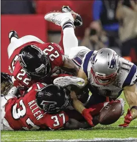  ?? PATRICK SEMANSKY / AP ?? Patriots receiver Julian Edelman makes a miraculous catch fighting off Ricardo Allen and Keanu Neal to turn what looked like an intercepti­on into a reception that helped New England rally to win the Super Bowl over the Falcons.