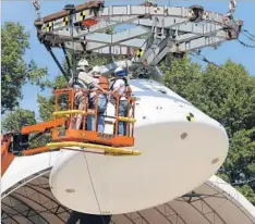  ?? Photograph­s by Steve Helber Associated Press ?? WORKERS PREPARE a replica of NASA’s Orion spacecraft for a splashdown test at the Langley Research Center in Hampton, Va.