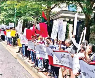  ??  ?? A group of Myanmar nationals staged a demonstrat­ion in front of the Singapore embassy in Washington on Monday.