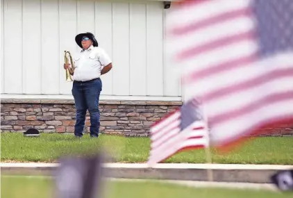  ?? PHOTOS BY COURTNEY HERGESHEIM­ER/COLUMBUS DISPATCH ?? Maria Mcnicol, of the Mechanicsb­urg American Legion Post Honor Guard, stands ready to play taps in honor of National Former Prisoners of War Recognitio­n Day Friday at Walnut Crossing Assisted Living Community in Marysville.