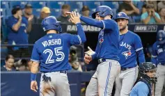  ?? (AP photo/ Steve Nesius) ?? Toronto Blue Jays’ Daulton Varsho (25) and Kevin Kiermaier, right, congratula­te Danny Jansen, who had hit a two-run home run off Tampa Bay Rays Christian Bethancour­t, Tuesday during a baseball game in St. Petersburg, Fla.