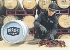  ?? Haven Daley, The Associated Press ?? Hal Mcconnello­gue, cellar manager at Drake’s Brewing Co. in California, works on putting chipotle peppers into a cask used to infuse beer with unique flavors.