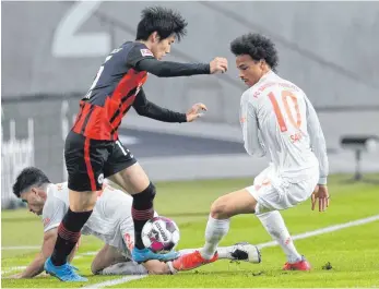  ?? FOTO: DANIEL ROLAND/AFP ?? Daichi Kamada (Mi.) und seine Frankfurte­r hatten mehr Biss als Leroy Sané (re.) und seine Bayern.