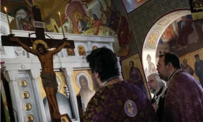  ??  ?? Greek Orthodox priests conduct an Easter service on Friday in a church behind closed doors in Athens. Photograph: Alkis Konstantin­idis/ Reuters