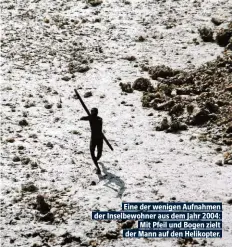  ??  ?? Eine der wenigen Aufnahmen der Inselbewoh­ner aus dem Jahr 2004: Mit Pfeil und Bogen zielt der Mann auf den Helikopter.