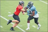  ?? BOB SELF — THE FLORIDA TIMES-UNION VIA AP ?? Jacksonvil­le Jaguars starting quarterbac­k Gardner Minshew II, left, hands the ball off to running back Leonard Fournette during NFL football training camp, Saturday, Aug. 29, 2020, in Jacksonvil­le, Fla.