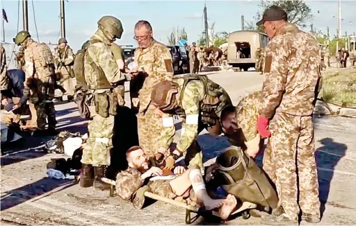  ?? AP
WAR IN EUROPE ?? Russian army has
suffered ‘impressive losses’ and it is unclear how long it can sustain its
campaign.
Russian servicemen frisk injured Ukrainian soldiers as they are evacuated from the besieged Azovstal steel plant in Mariupol, Ukraine.