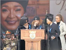  ?? THEMBA HADEBE — THE ASSOCIATED PRESS ?? Sisters Zindzi, left, and Zenani, center, pay tribute Saturday to their mother amd icon, Winnie Madikizela-Mandela, shown in the background, at her funeral at the Orlando Stadium in Soweto, South Africa.