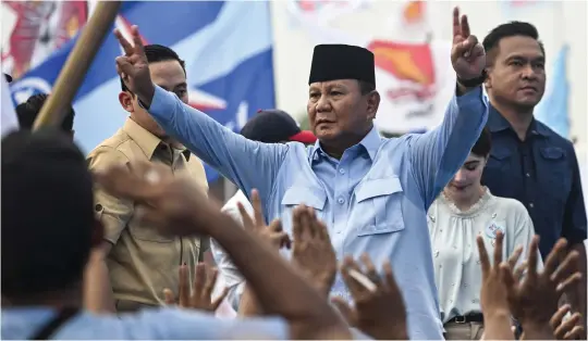  ?? Photo by JUNI KRISWANTO / AFP ?? Indonesian Defence Minister and presidenti­al candidate Prabowo Subianto gestures to his supporters as he arrives at an election campaign rally in Sidoarjo, East Java, on February 9, 2024.