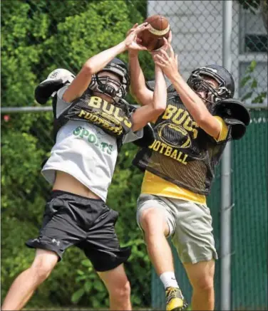  ??  ?? PETE BANNAN — DIGITAL FIRST MEDIA Interboro players Dan Coll and Andrew Grieb vie for a pass during August football camp.