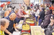  ?? MARLA BROSE/JOURNAL ?? Volunteers and community leaders, including Rio Rancho Mayor Gregg Hull, bottom left, serve a Thanksgivi­ng meal to needy people last year at McDonald’s.