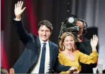  ?? — Reuters ?? All smiles: (Top) Trudeau arriving to speak to supporters and (left) waving alongside his wife Sophie Gregoire Trudeau after the federal election at the Palais des Congres in Montreal.